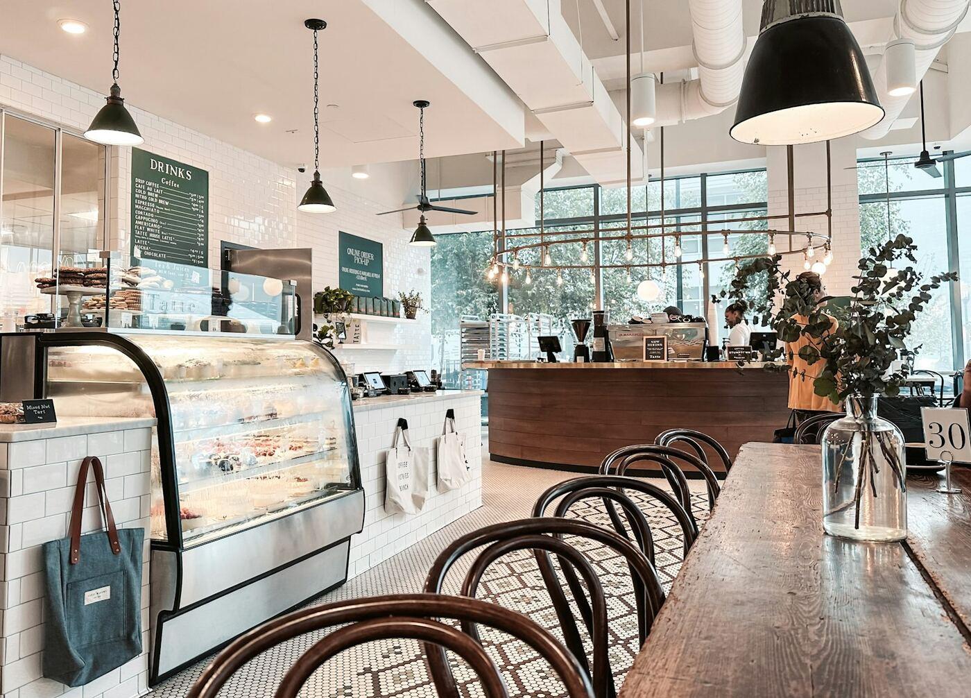 Café counter with pastry display and bentwood chairs